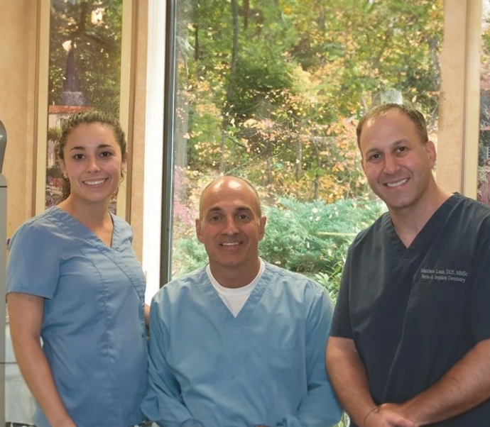 Doctor Salem smiling with two Braintree dental team members