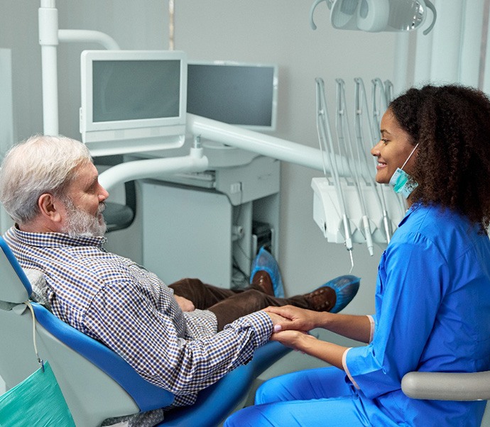 Dental team member and senior patient having conversation