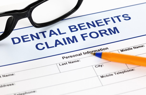 Dental benefits claim form with pen and glasses