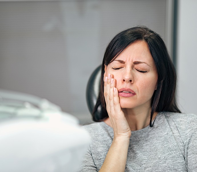 Patient with toothache sitting in treatment chair