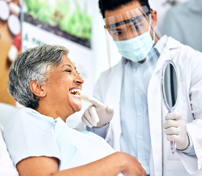 Dentist showing patient smiling in reflection