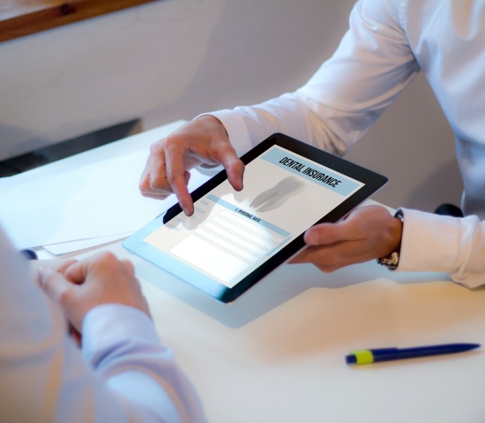 Two people looking at dental insurance information on tablet