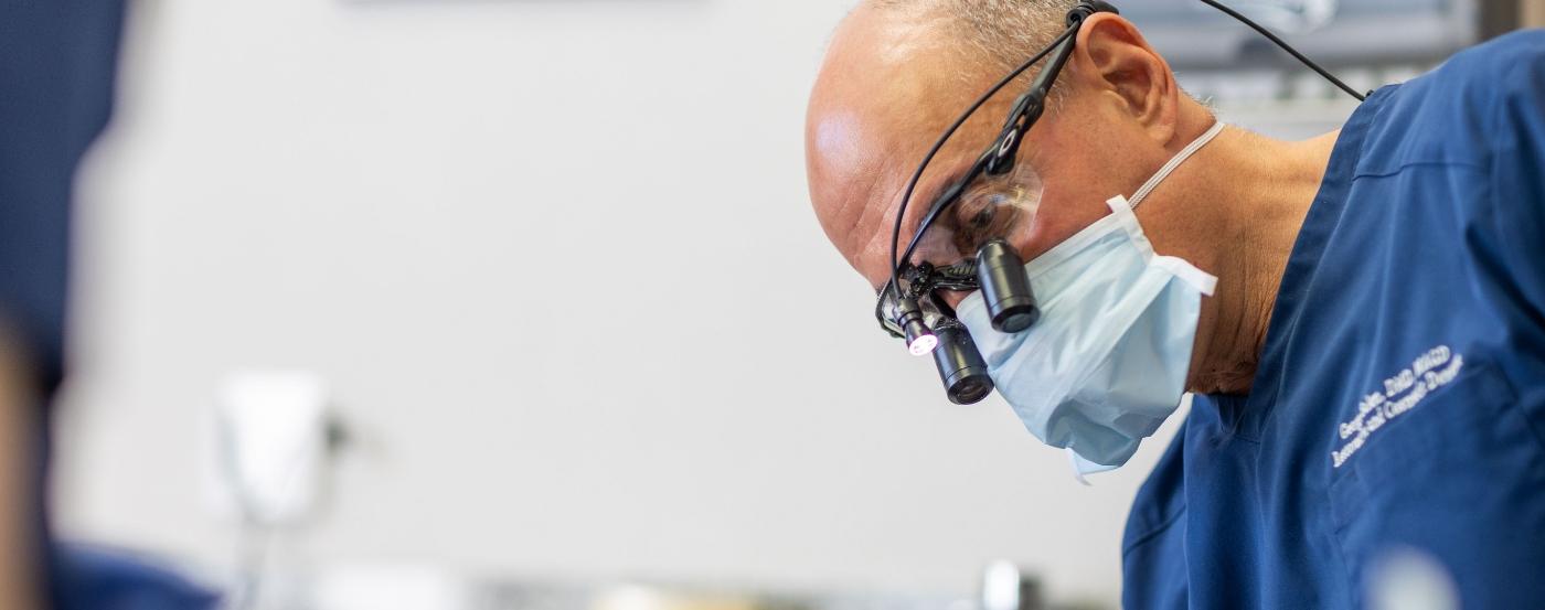 Doctor Salem wearing dental binoculars while treating a patient