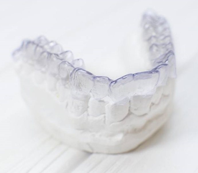 Hand holding an Invisalign clear aligner in Braintree