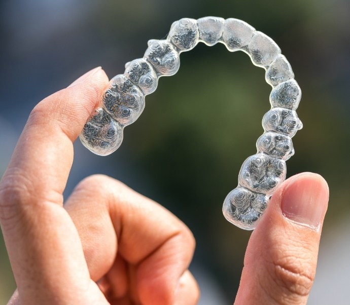 Hand holding an Invisalign clear aligner in Braintree