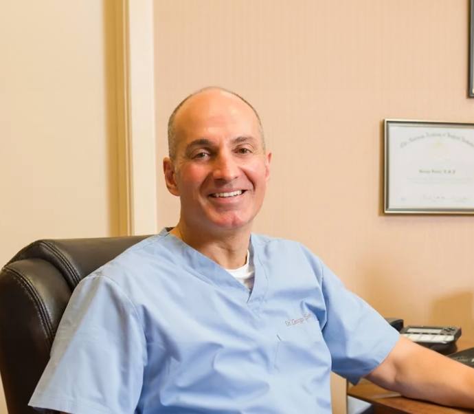 Doctor Salem smiling while sitting in chair at desk