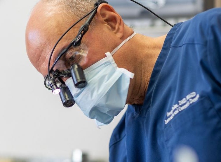 Doctor Salem wearing dental binoculars while treating a patient