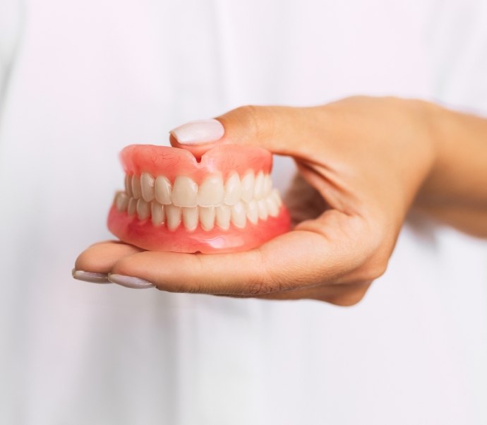 Dentist holding a set of dentures