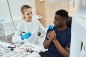 Man looking nervous as dentist tried to reassure him before treatment